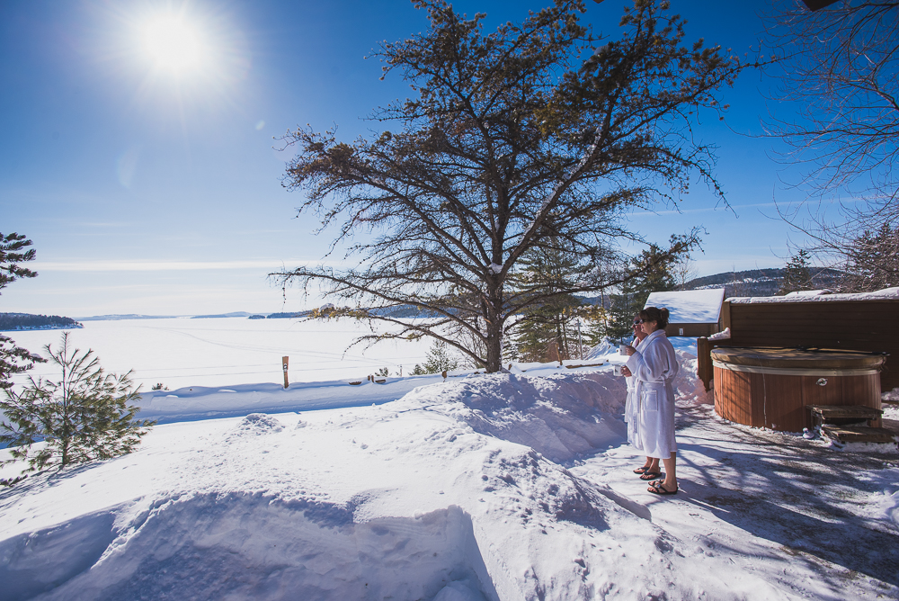Vue extérieure d'un chalet avec spa privatif de la Bannik avec une vue sur le lac Témiscamingue gelé. Un séjour à La Bannik, au Témiscamingue, est l'une des activités hivernales que l'on préfère!