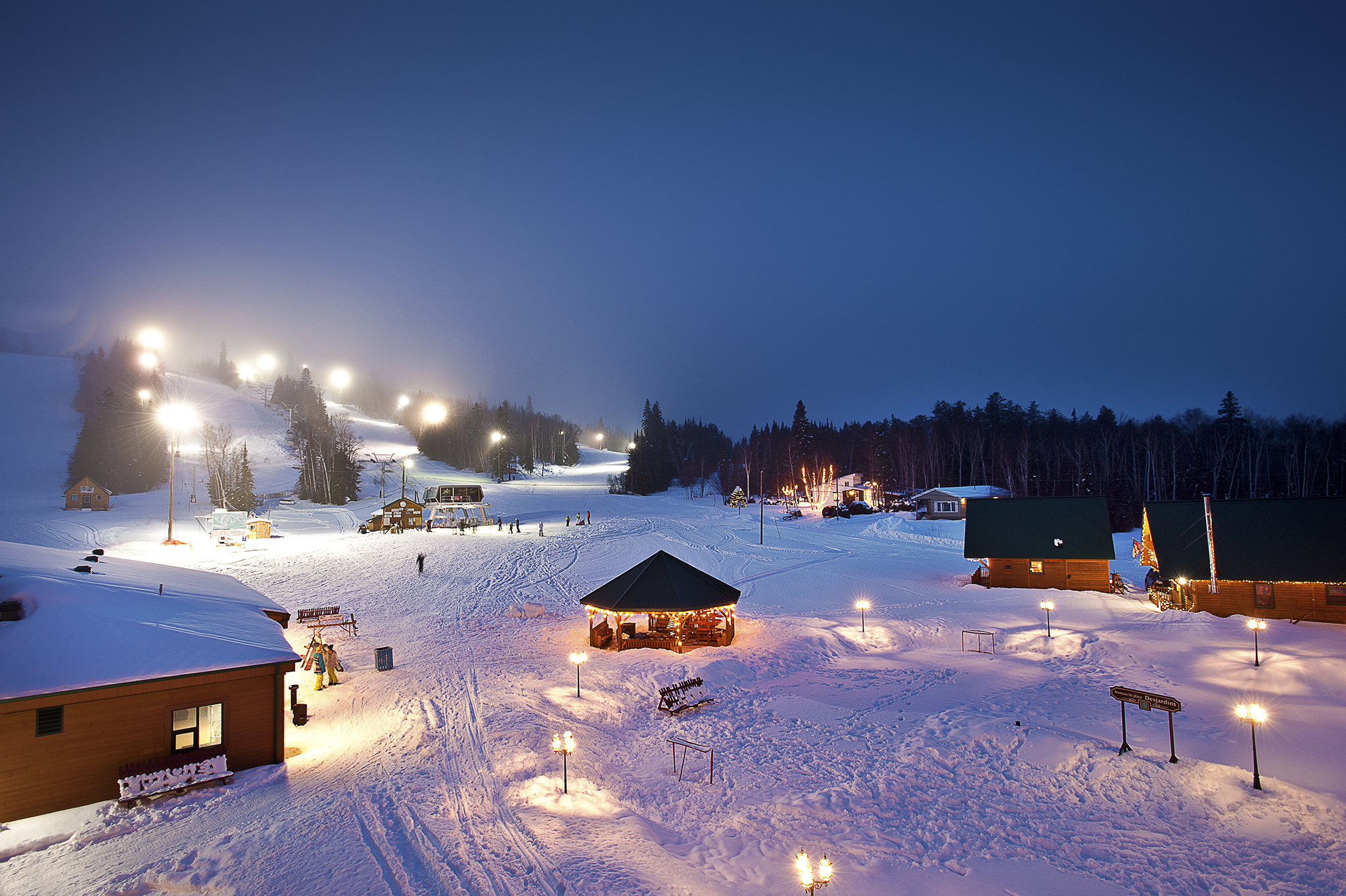 Vue de nuit de la station de ski alpin Mont-Vidéo, à Barraute, en Abitibi-Témiscamingue. Le ski alpin et la planche à neige sont les activités hivernales par excellence dans la région.